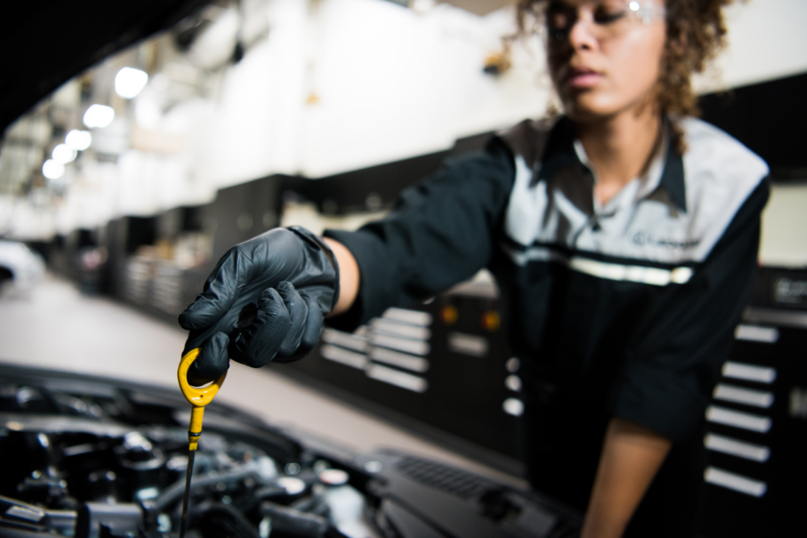 Lexus oil change technician checking dipstick