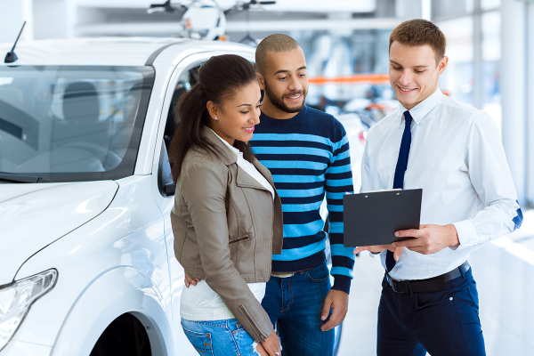 Dealer and customers looking at paperwork