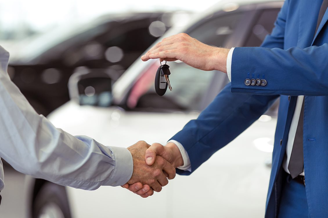 Dealer handing keys to a customer at lease return.